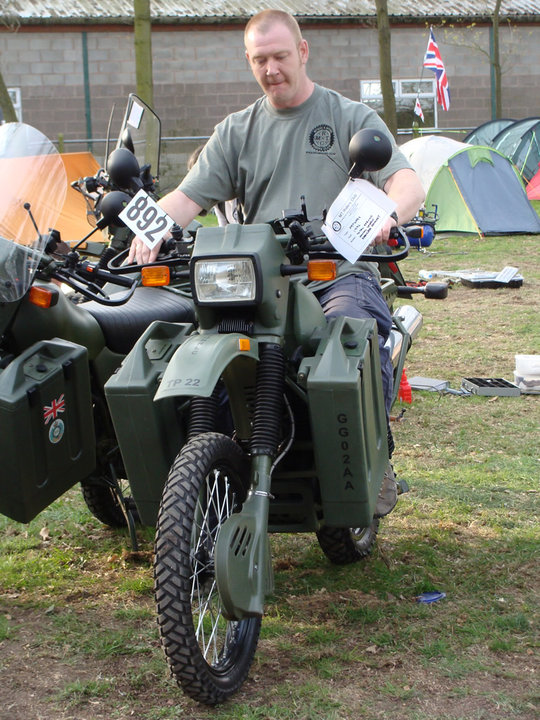 A man sitting on a Harley-Davidson MT350 displayed at a show